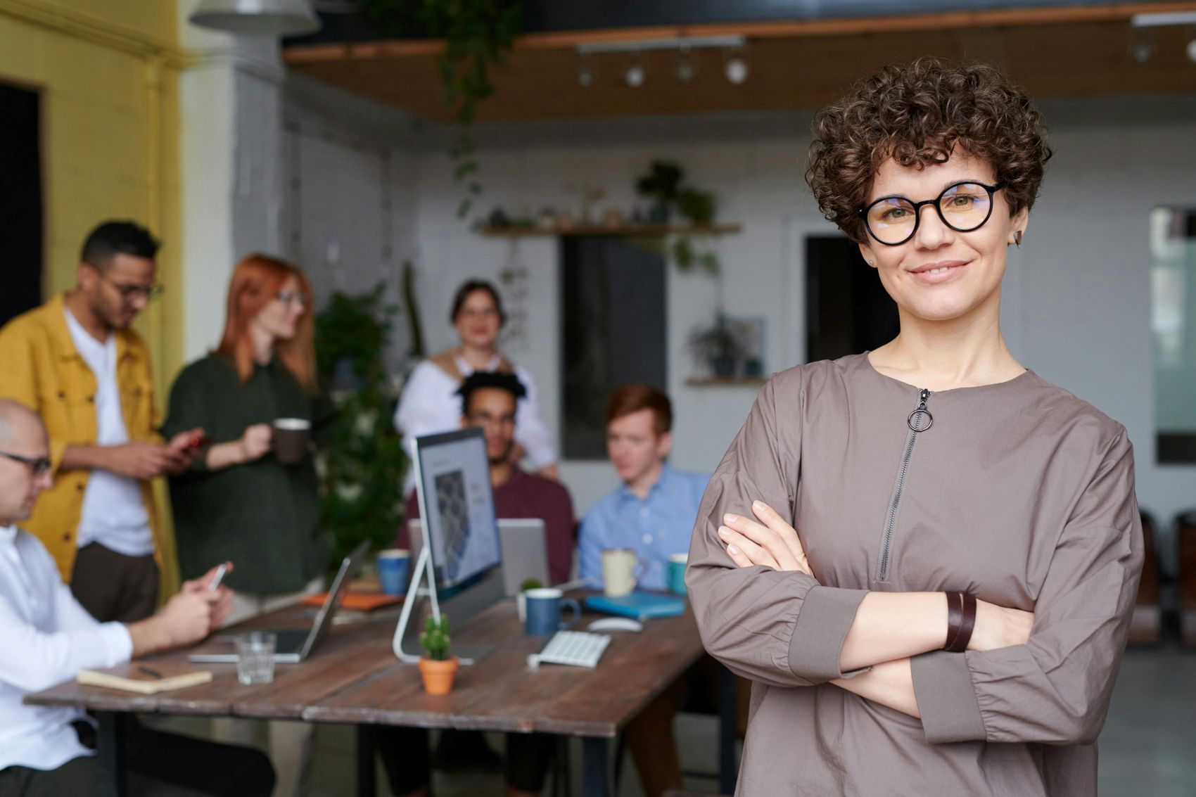 Person smiling confidently at the camera with their arms crossed